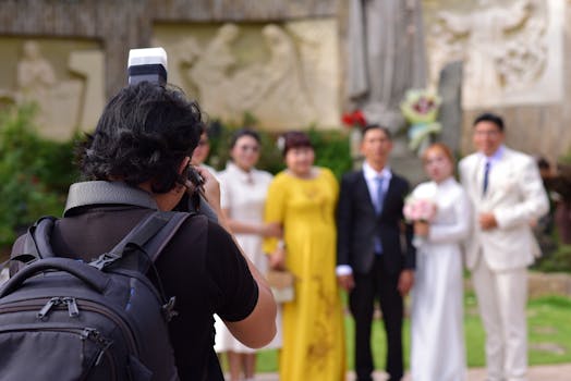 A photographer takes pictures of a wedding ceremony with happy couples and guests outside.